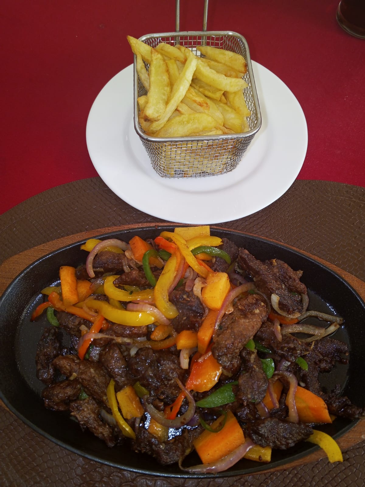 Sizzling beef stir-fry with basket of chips